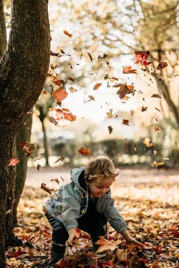 Kind wirft Blätter